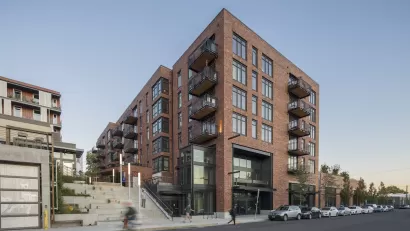 Photo of Goat Blocks development, Portland, Oregon with five-story brick building and wide concrete staircase.